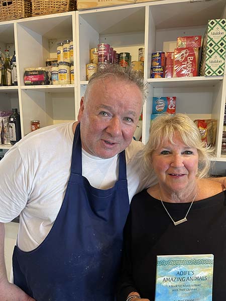 thomas Ryan with Meri they are holding book in store